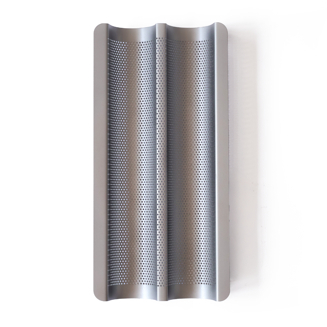 Non-stick perforated baguette tray for baking crisp baguettes