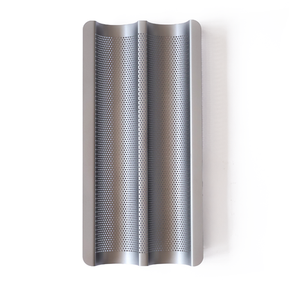 Non-stick perforated baguette tray for baking crisp baguettes